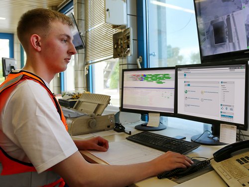 Auszubildender sitzt an einem Computer-Arbeitsplatz mit mehreren Monitoren. Auf einem sieht man die Plattform BetonQuali.