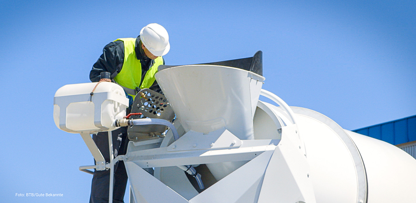 Fahrmischer-Fahrer schaut in Trichter des Fahrmischers
