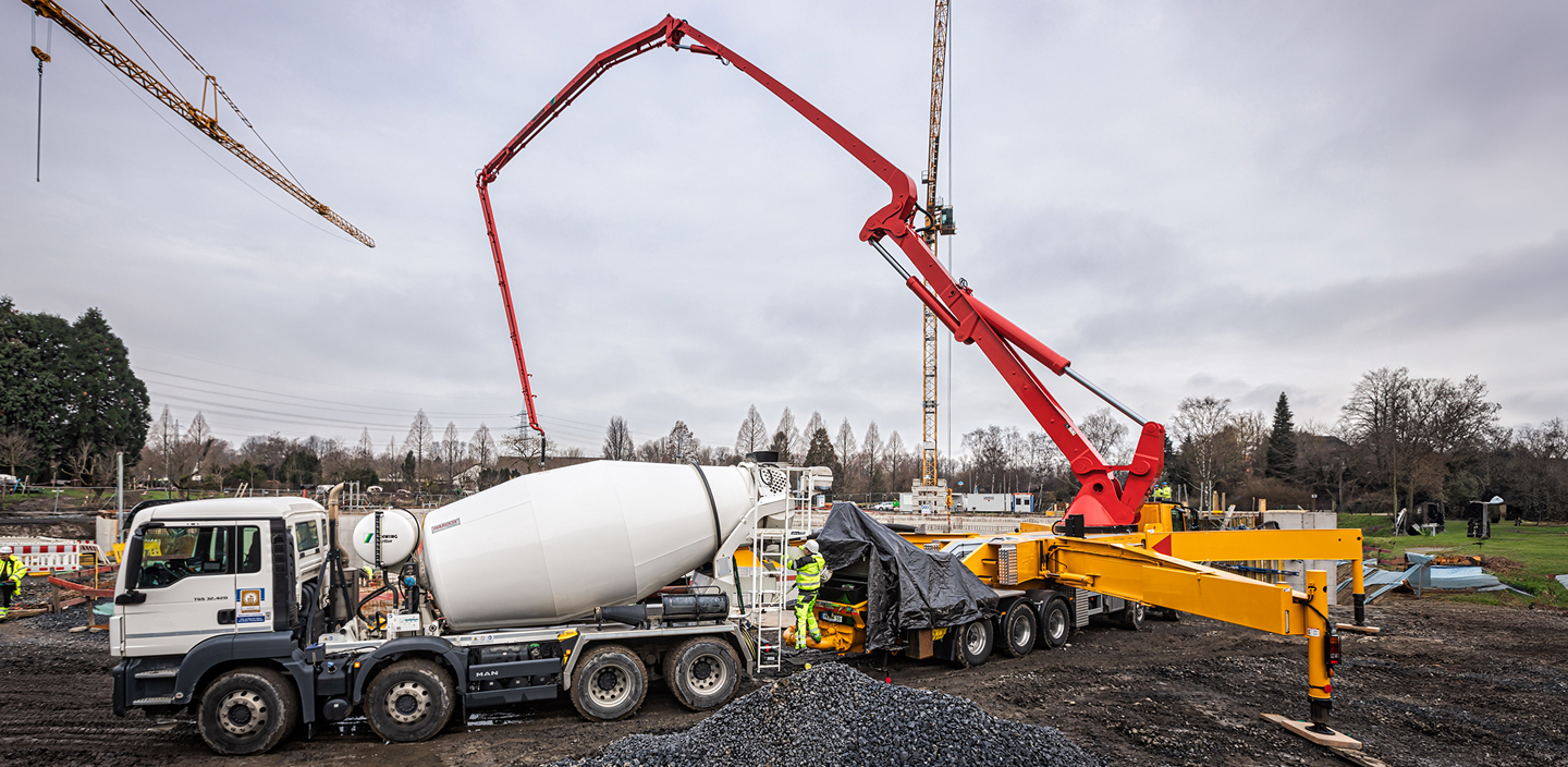 Eine Betonpumpe und ein Fahrmischer auf einer Baustelle
